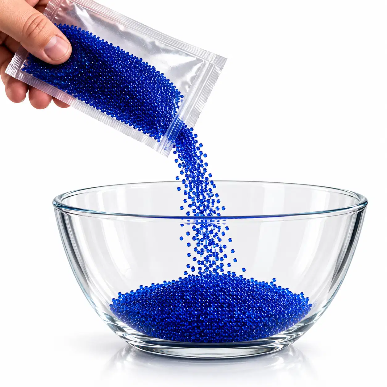Sachet de billes d’Orbeez déshydratées versé dans un saladier en verre